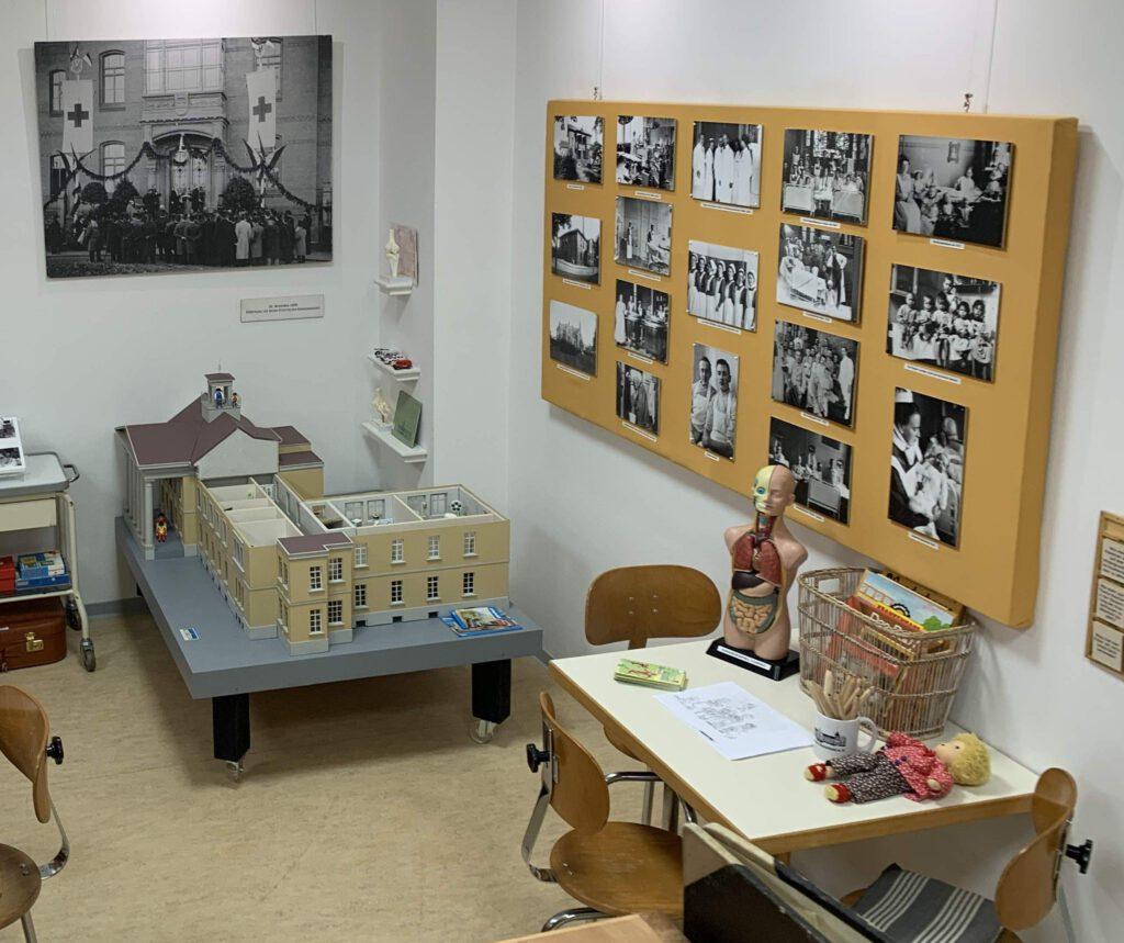 Kinderecke mit einem geöffneten Krankenhausmodell und historischen Fotos